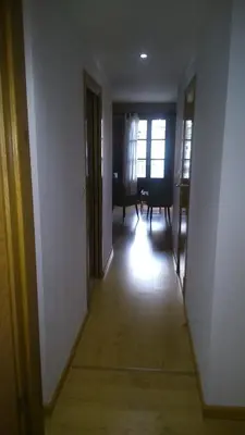 an empty room with a hallway with a table and chairs at Apartamento con balcón in Viveiro