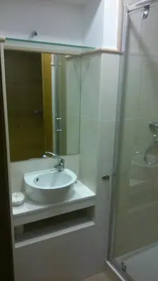 a bathroom with a sink and a glass shower at Apartamento con balcón in Viveiro