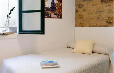 a bedroom with a bed with a book on it at Pensión Rua Nova in Santiago de Compostela