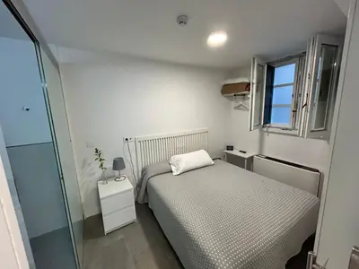 a small bedroom with a bed and a window at Pensión Rua Nova in Santiago de Compostela