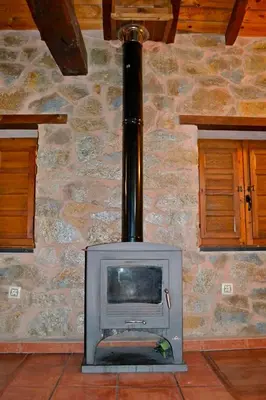 a stone wall with a stove in a room at Pedrazales Rural in Pedrazales