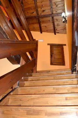 a staircase in a building with wooden ceilings at Pedrazales Rural in Pedrazales