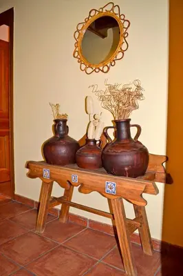 three vases sitting on a wooden table with a mirror at Pedrazales Rural in Pedrazales