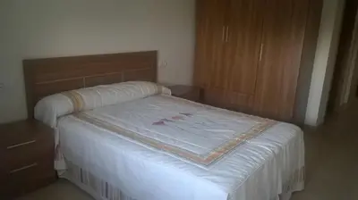 a bedroom with a bed and a wooden cabinet at Apartamentos Alejandra in Barreiros