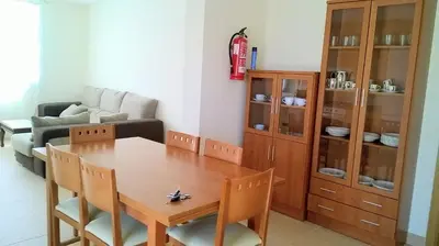 a living room with a wooden table and a couch at Apartamentos Alejandra in Barreiros