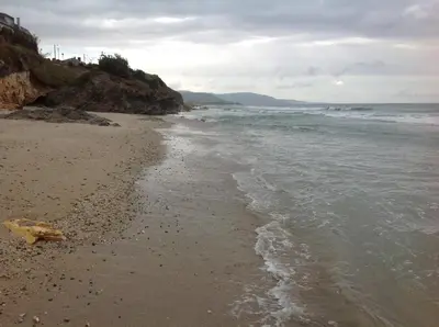 a beach with the ocean and a cloudy sky at Apartamentos Alejandra in Barreiros