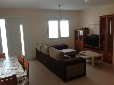a living room with a couch and a tv at Apartamentos Alejandra in Barreiros
