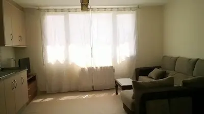 a living room with a couch and a large window at Apartamentos Alejandra in Barreiros