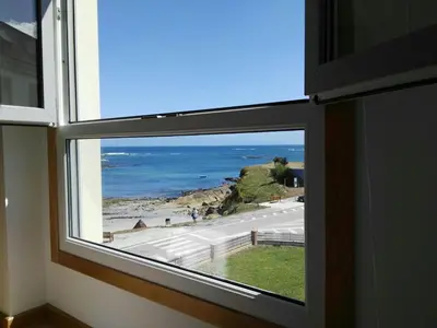 a window with a view of the ocean at San Ciprián Playa y Mar by I Love Norte in San Ciprián