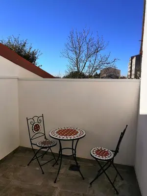 two chairs and a table on a patio at Albergue Pensión Cima do Lugar in Arzúa