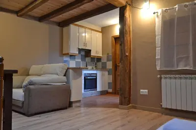 a living room with a couch and a kitchen at Hotel Rural La Casa de Irene in Lubián