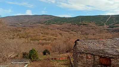 an old stone building in the middle of a mountain at Hotel Rural La Casa de Irene in Lubián