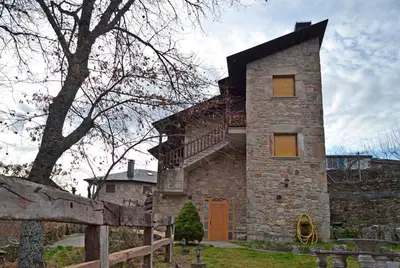a stone house with a staircase on the side of it at Hotel Rural La Casa de Irene in Lubián