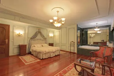 a bedroom with a bed and a tub and a chandelier at Pazo de Monterrei in Ourense
