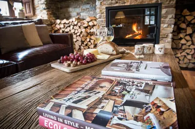 a living room with books on a table with a fireplace at Aldea Rural y Gastro Restaurante Casona de Labrada in Labrada