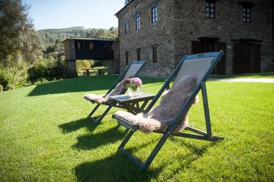 two chairs sitting on the grass in a yard at Aldea Rural y Gastro Restaurante Casona de Labrada in Labrada