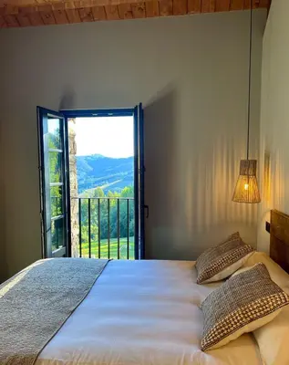 a bedroom with a bed with a large window at Aldea Rural y Gastro Restaurante Casona de Labrada in Labrada