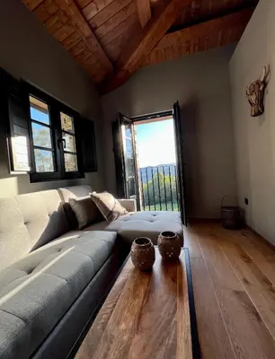 a living room with a couch and a large window at Aldea Rural y Gastro Restaurante Casona de Labrada in Labrada