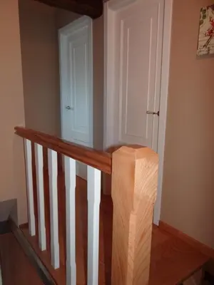 a staircase with a wooden rail and a white door at Casa do Forno in Castro de Oro