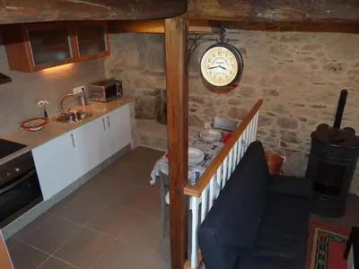 a kitchen with a sink and a clock on the wall at Casa do Forno in Castro de Oro