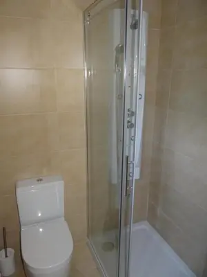 a bathroom with a toilet and a glass shower at Casa do Forno in Castro de Oro