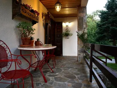a patio with chairs and a table on a porch at Casa da Curuxeira in Santiago de Compostela