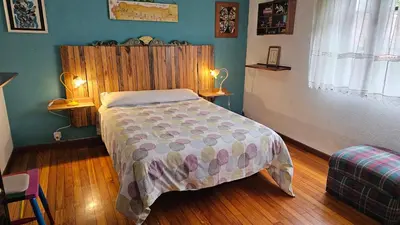 a bedroom with a bed with a wooden headboard at Casa da Curuxeira in Santiago de Compostela