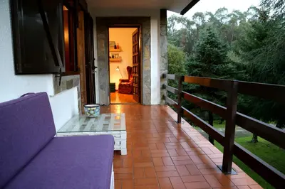 a porch of a house with a couch and a table at Casa da Curuxeira in Santiago de Compostela