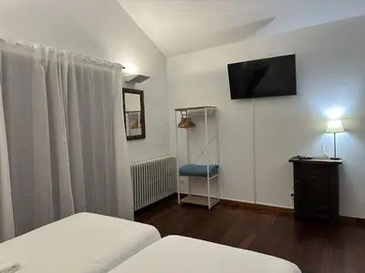 a room with two beds and a television on the wall at Casa Boado in Boimorto