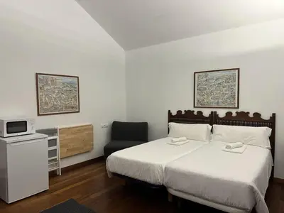 a bedroom with a large bed and a chair at Casa Boado in Boimorto