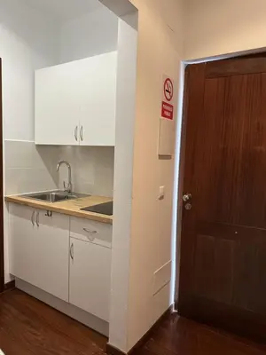 a kitchen with white cabinets and a sink and a door at Casa Boado in Boimorto
