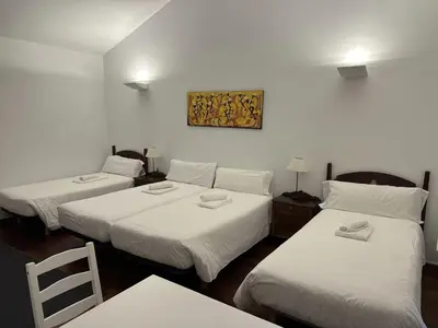 a room with three beds and a picture on the wall at Casa Boado in Boimorto