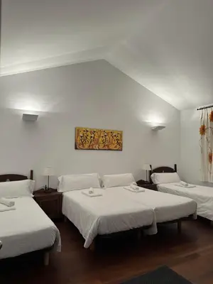 a room with three beds and a painting on the wall at Casa Boado in Boimorto