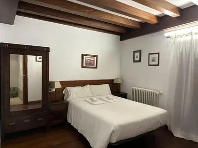 a bedroom with a white bed and a mirror at Casa Boado in Boimorto