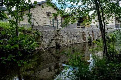 a stone building next to a body of water at Casa Rural 