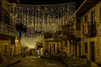 an alley with christmas lights in an old town at night at Casa Rural 