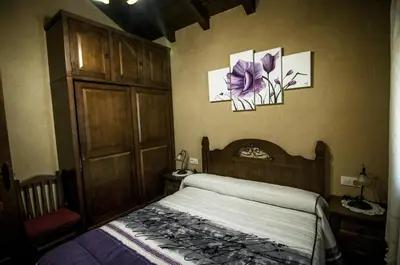 a bedroom with a bed and two pictures on the wall at Casa Rural 