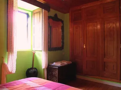 a bedroom with green walls and a bed with a window at Apartamentos Turísticos Casa dos Pulidos in Olás de Villariño