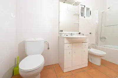 a white bathroom with a toilet and a sink at Apartamentos Turísticos Casa dos Pulidos in Olás de Villariño