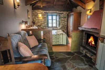 a living room with a couch and a fireplace at Apartamentos Rurales Casa Riveras in Santa Eulalia de Oscos