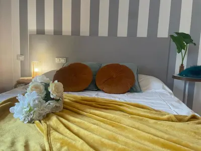 a bed with two pillows and flowers on it at Gloria's Design House in Santiago de Compostela
