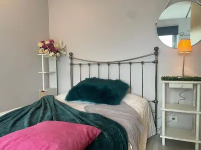 a bedroom with a metal bed with a mirror at Gloria's Design House in Santiago de Compostela