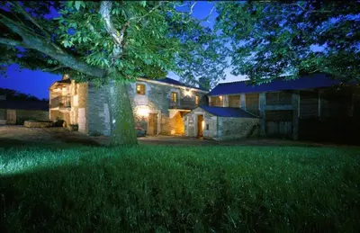 a large house with a tree in front of it at Casa Lourán in Monfero