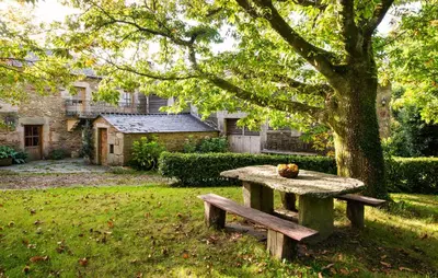 a picnic table sitting under a tree in a yard at Casa Lourán in Monfero