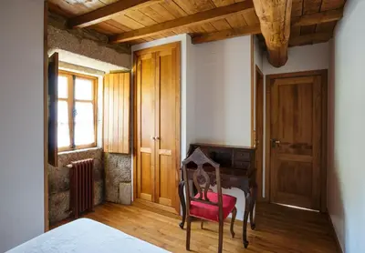 a bedroom with a desk and a red chair at Casa Lourán in Monfero