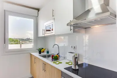 a white kitchen with a sink and a window at Rueiro 17 in A Coruña