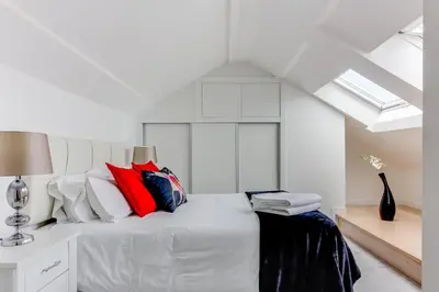 a bedroom with a white bed with red and blue pillows at Rueiro 17 in A Coruña