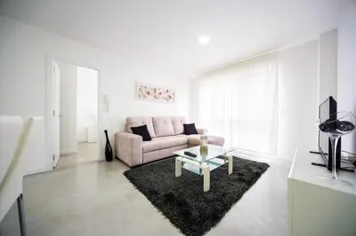 a living room with a pink couch and a table at Rueiro 17 in A Coruña