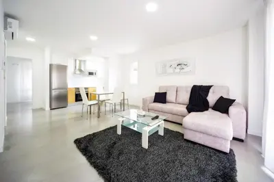a living room with a pink couch and a table at Rueiro 17 in A Coruña