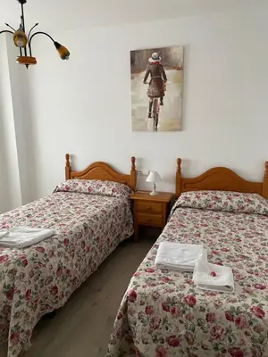a bedroom with two beds and a picture of a person riding a bike at Convento de Foncebadon in Foncebadón